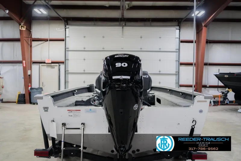 Slide: The Image of 2026 Lund 1875 Pro Guide boat with Mercury 90 engine in a garage. - 7