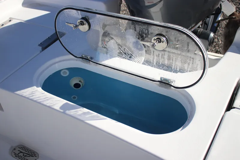 Slide: The Image of Livewell on 2026 Tidewater 2110 Bay Max boat, featuring a clear lid and blue interior. - 22