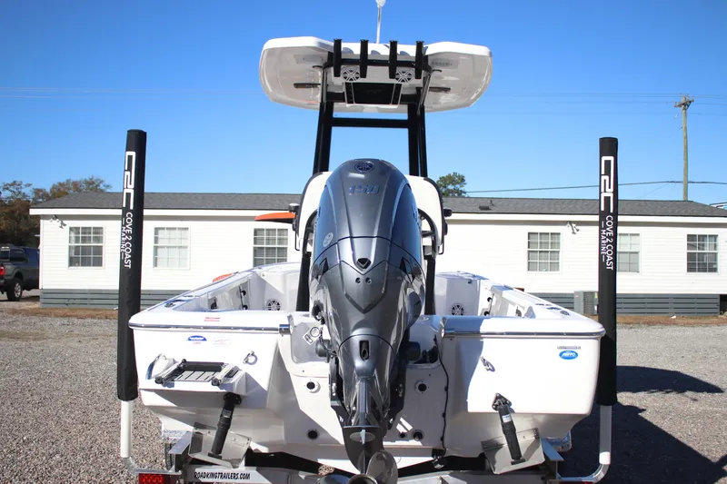 Slide: The Image of 2026 Tidewater 2110 Bay Max boat with powerful outboard motor, parked on gravel. - 24