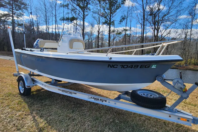 Slide: The Image of 2017 Key West 1720 Center Console boat on trailer, parked near a lake. - 1