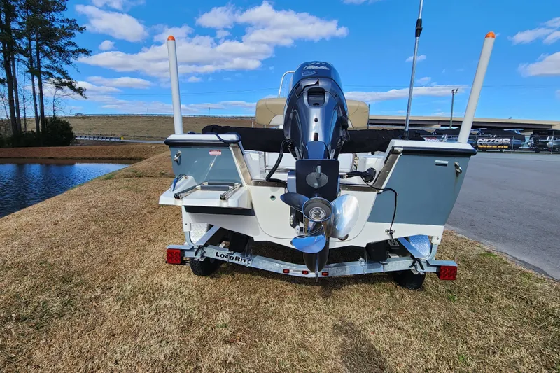 Slide: The Image of 2017 Key West 1720 Center Console boat on trailer, parked near a pond under blue sky. - 4
