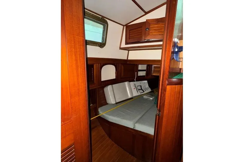 Slide: The Image of 1986 Crealock 40 sailboat interior with wooden paneling and cushioned seating. - 18