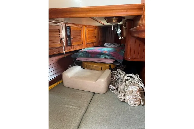 Slide: The Image of 1986 Crealock 40 sailboat interior with wooden cabinets and nautical ropes. - 19