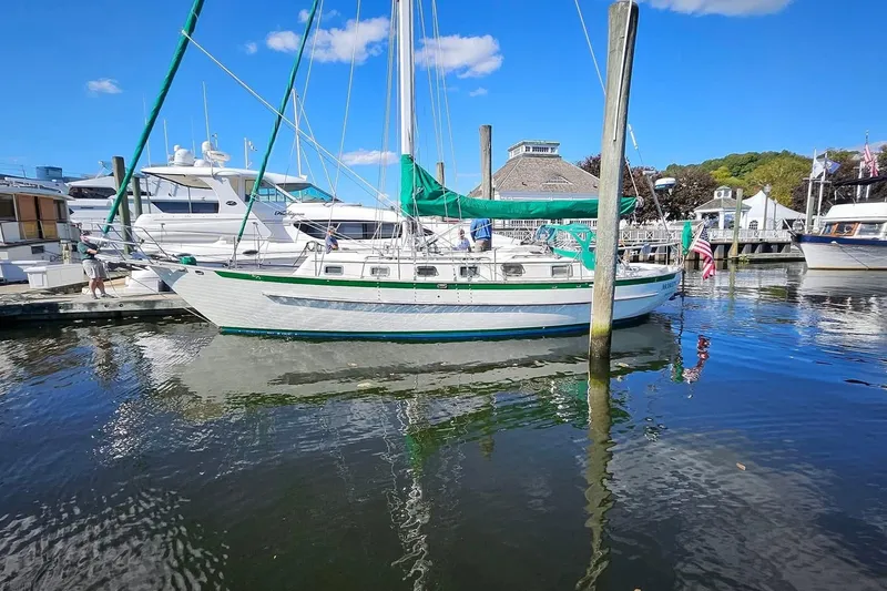 Slide: The Image of 1986 Crealock 40 sailboat docked at a marina under a clear blue sky. - 2