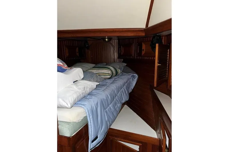Slide: The Image of Cozy cabin interior of 1986 Crealock 40 sailboat with wooden paneling and bedding. - 20