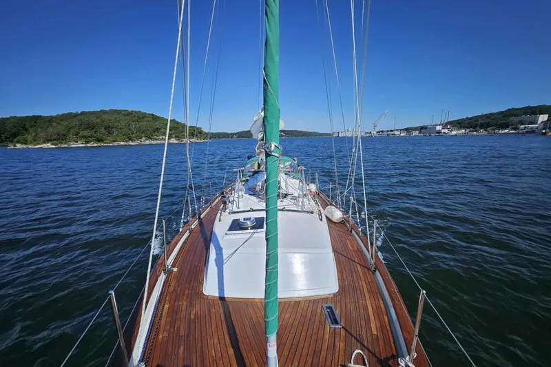 Slide: The Image of 1986 Crealock 40 sailboat on calm waters with scenic shoreline view. - 3
