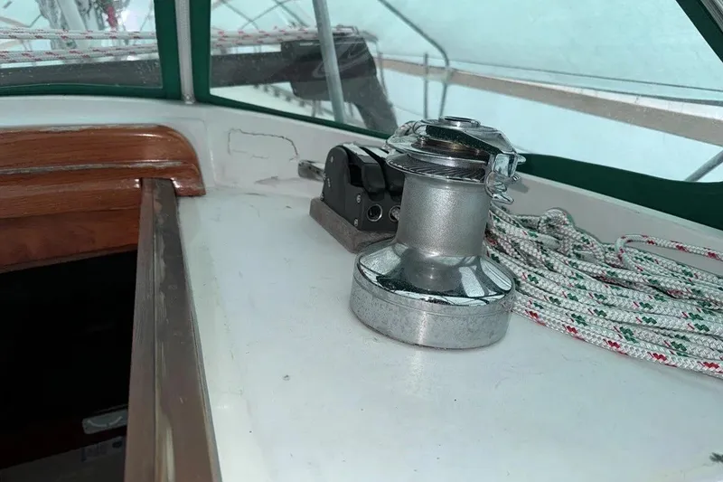 Slide: The Image of Winch and ropes on 1986 Crealock 40 sailboat deck, featuring wood trim and green canopy. - 5