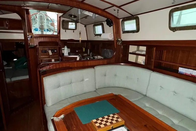 Slide: The Image of Interior of 1986 Crealock 40 sailboat with cozy seating and wooden accents. - 6