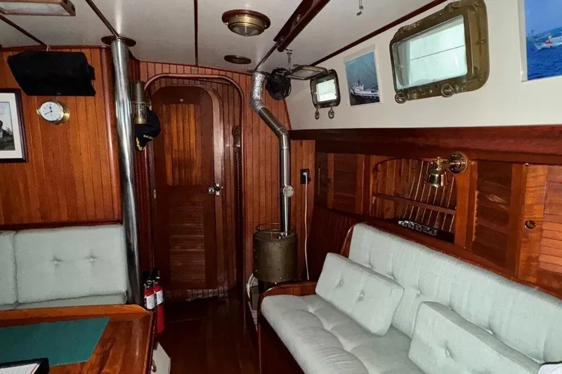 Slide: The Image of Interior of 1986 Crealock 40 sailboat with wood paneling and cozy seating area. - 7