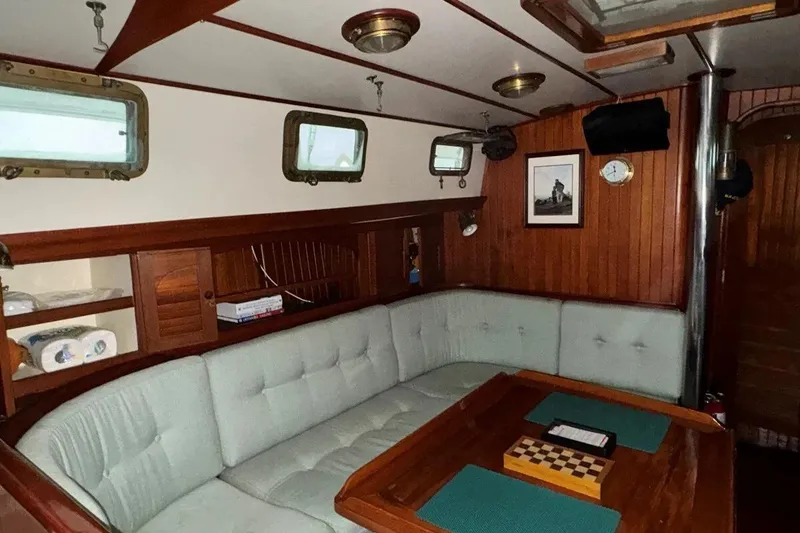 Slide: The Image of Interior of 1986 Crealock 40 sailboat with cozy seating and wooden accents. - 8