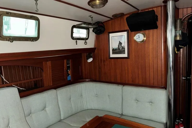 Slide: The Image of Interior of 1986 Crealock 40 sailboat with wood paneling and cushioned seating. - 9