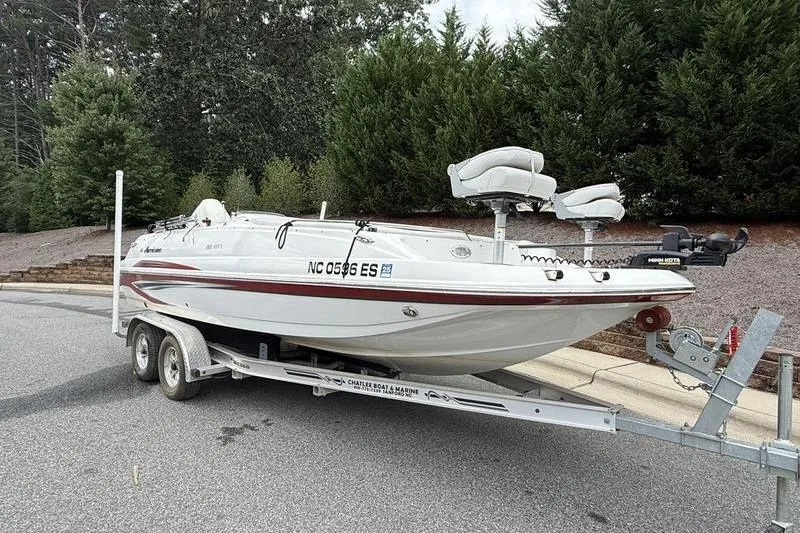 Slide: The Image of 2021 Hurricane SunDeck Sport 201 OB boat on trailer, parked on a road. - 2