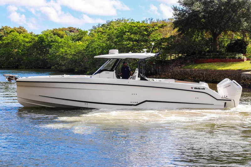 Slide: The Image of 2026 Wellcraft 38 T-Top boat cruising on a scenic waterway. - 32