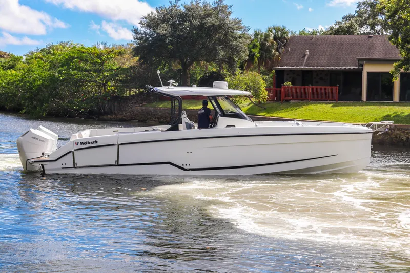 Slide: The Image of 2026 Wellcraft 38 T-Top boat cruising on a scenic waterway. - 35