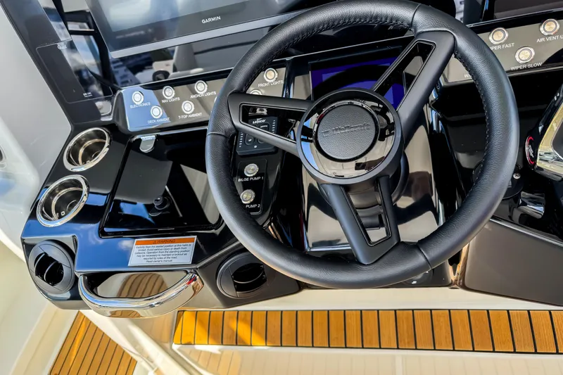 Slide: The Image of Steering wheel and controls of 2026 Wellcraft 38 T-Top boat, featuring modern dashboard design. - 19