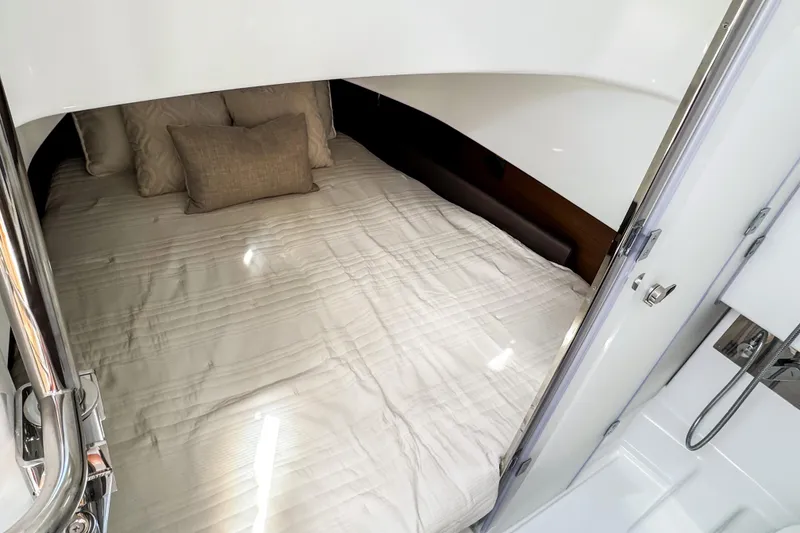 Slide: The Image of 2026 Wellcraft 38 T-Top cabin interior with cozy bed and pillows. - 23