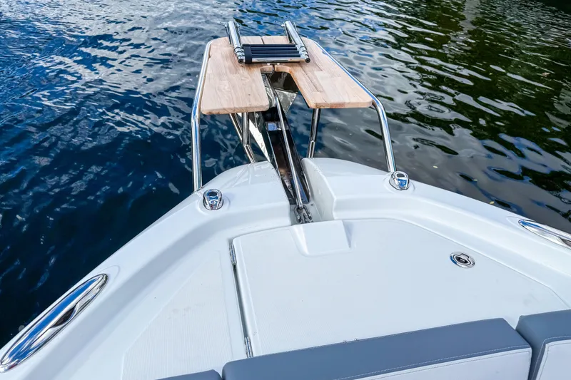 Slide: The Image of Bow view of 2026 Wellcraft 38 T-Top boat with wooden platform and water backdrop. - 29