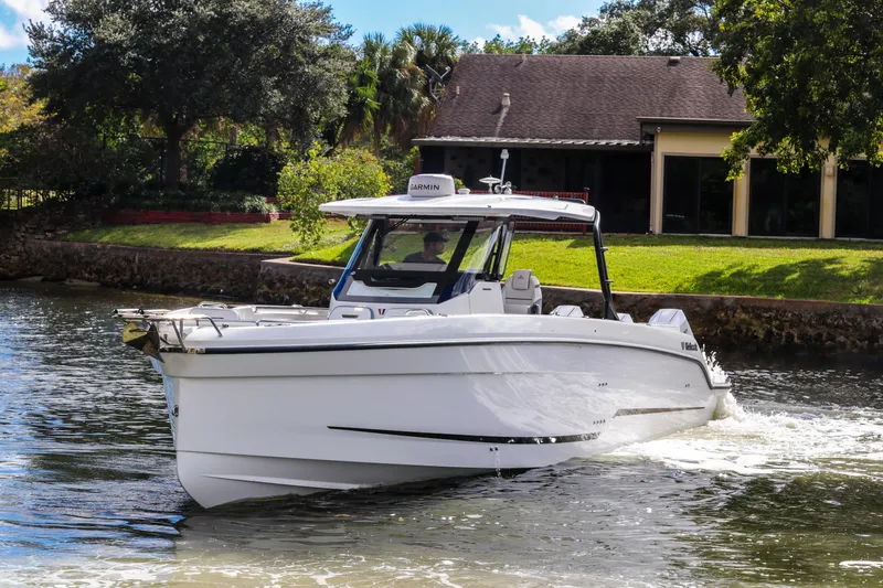 Slide: The Image of 2026 Wellcraft 38 T-Top boat cruising on a sunny day near a waterfront home. - 33