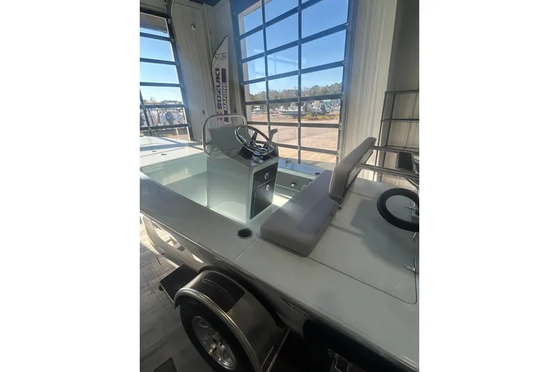 Slide: The Image of 2026 East Cape Evo 17X boat interior with steering console and seating in showroom. - 8