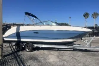 Slide: The Image of 2023 Sea Ray SDX 250 Outboard boat on trailer, parked outdoors under clear blue sky. - 5