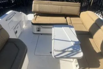Slide: The Image of 2023 Sea Ray SDX 250 Outboard interior with beige seating and white table. - 7