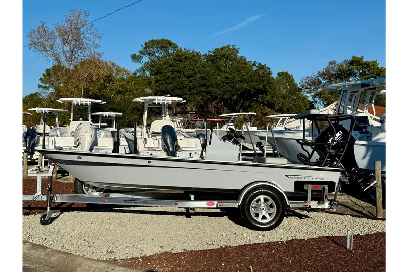 Slide: The Image of 2026 East Cape EVO 17V boat on trailer, surrounded by other boats, under clear blue sky. - 2