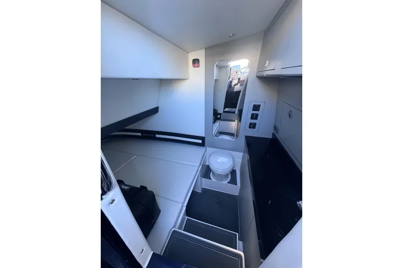 Slide: The Image of Interior of 2026 Mystic Powerboats M3800, featuring compact cabin with bed and toilet. - 11