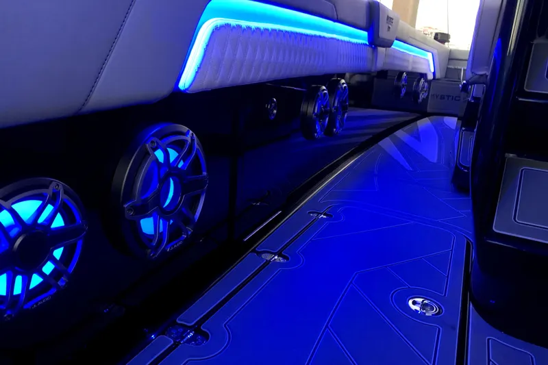Slide: The Image of Interior of 2026 Mystic Powerboats M3800 with blue LED lighting and speakers. - 5