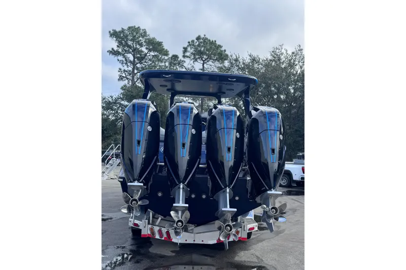Slide: The Image of 2026 Mystic Powerboats M3800 with four powerful outboard engines, parked outdoors. - 7