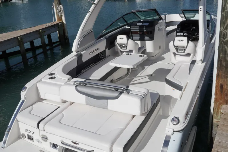 Slide: The Image of 2019 Chaparral 227 SSX boat interior with seating and table, docked by the water. - 13