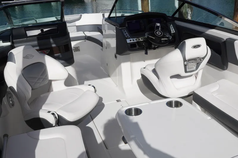 Slide: The Image of 2019 Chaparral 227 SSX boat interior with white seating and modern dashboard. - 14
