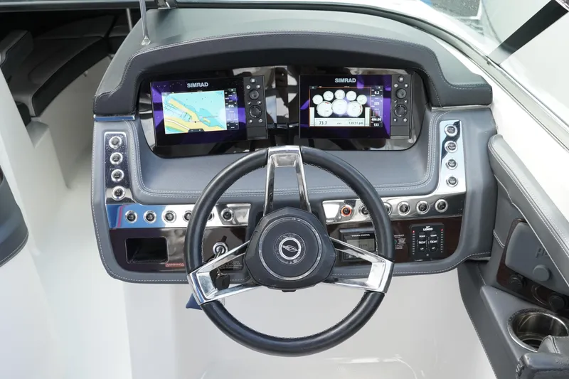 Slide: The Image of 2019 Chaparral 227 SSX boat dashboard with dual Simrad displays and steering wheel. - 19