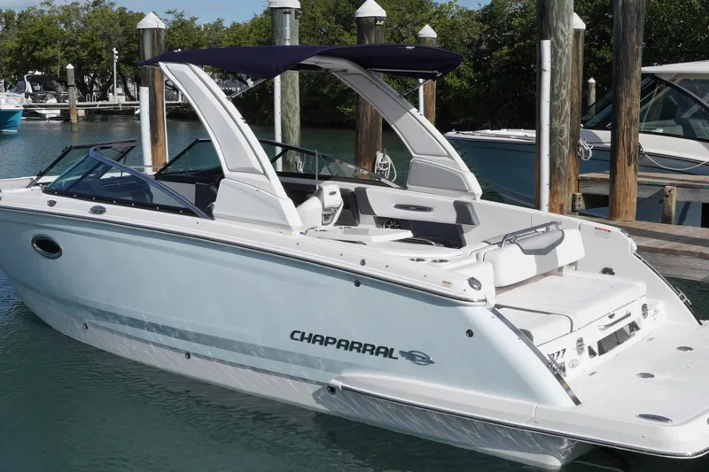 Slide: The Image of 2019 Chaparral 227 SSX boat docked in a marina, featuring sleek design and spacious seating. - 8