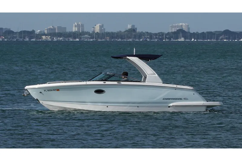 The Image of 2019 Chaparral 227 SSX boat cruising on water with city skyline in background. - 0