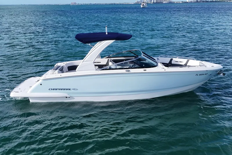 Slide: The Image of 2019 Chaparral 227 SSX boat on open water, featuring sleek design and blue canopy. - 4
