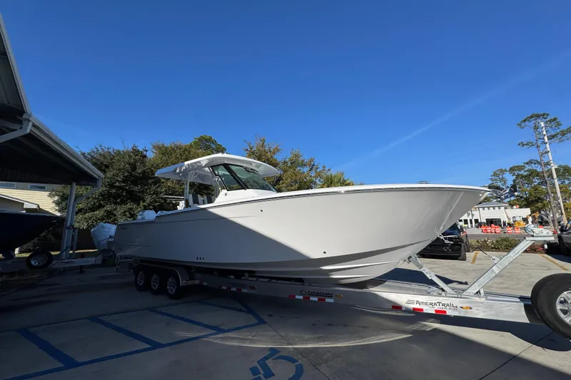 Slide: The Image of 2026 Bertram 34 CC boat on trailer under clear blue sky. - 10