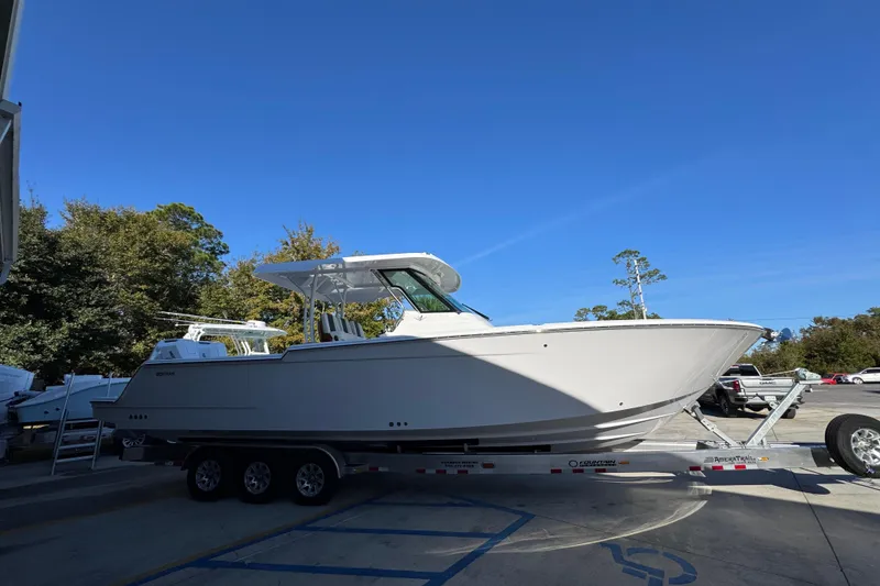 Slide: The Image of 2026 Bertram 34 CC boat on trailer, parked outdoors under clear blue sky. - 11