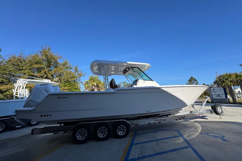 Slide: The Image of 2026 Bertram 34 CC boat on trailer under clear blue sky. - 12