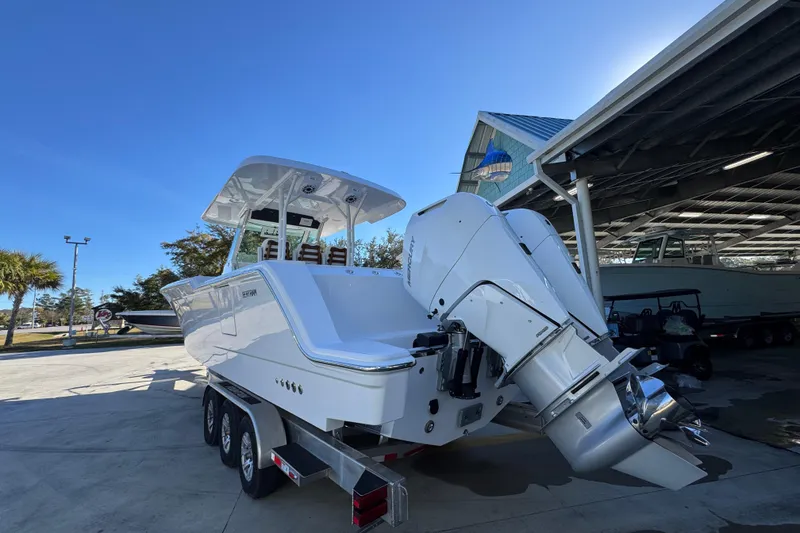 Slide: The Image of 2026 Bertram 34 CC boat with dual outboard engines in a marina setting. - 17