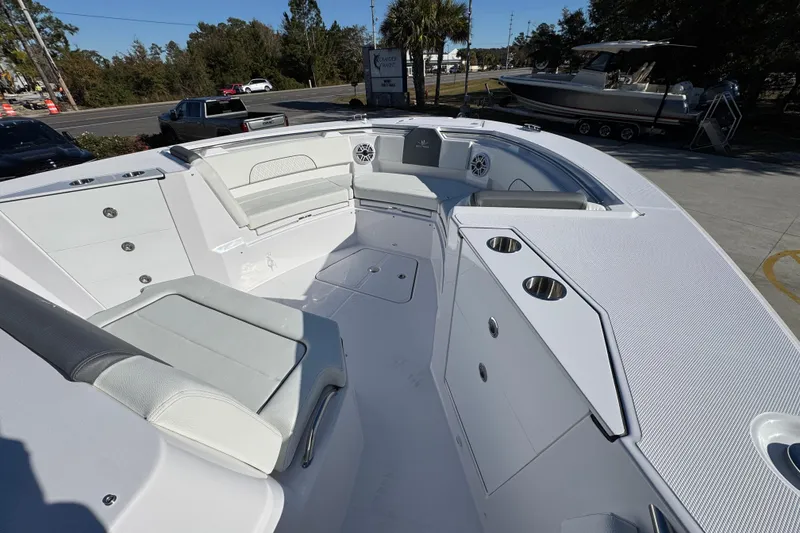 Slide: The Image of 2026 Bertram 34 CC boat interior with seating and cup holders, parked outdoors. - 19