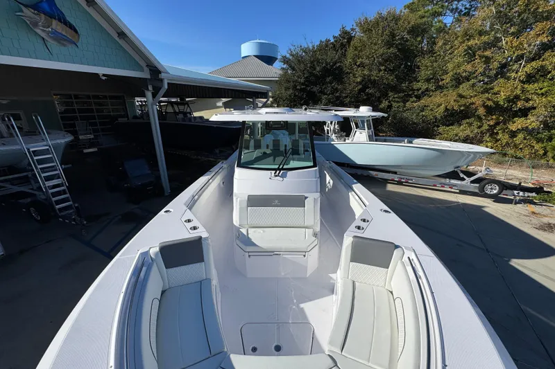 Slide: The Image of 2026 Bertram 34 CC boat with sleek design, docked outdoors under clear blue sky. - 23