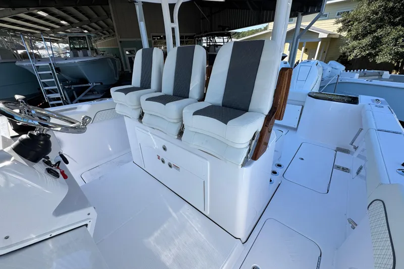 Slide: The Image of 2026 Bertram 34 CC boat interior with three cushioned seats and steering wheel. - 28