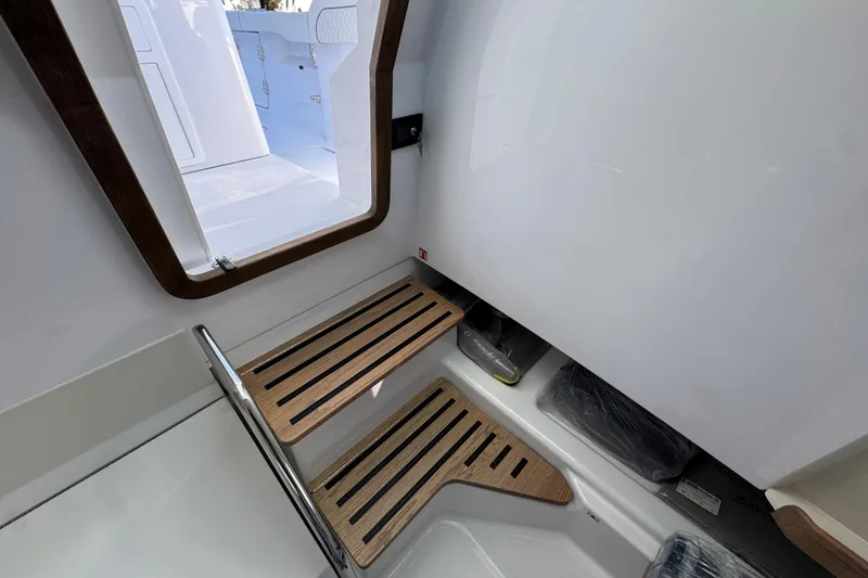 Slide: The Image of Interior of 2026 Bertram 34 CC boat, featuring wooden steps and sleek design. - 39