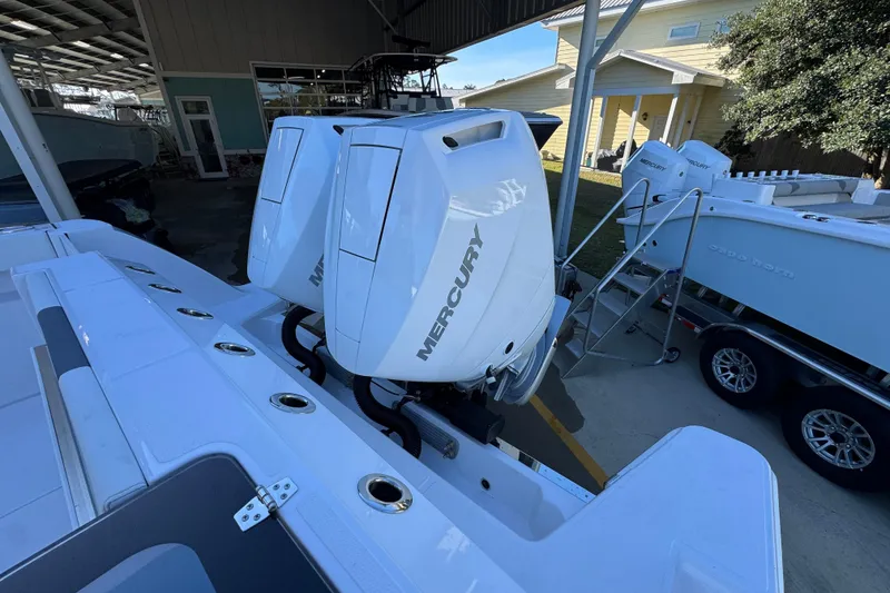 Slide: The Image of 2026 Bertram 34 CC boat with dual Mercury outboard engines in a marina setting. - 47
