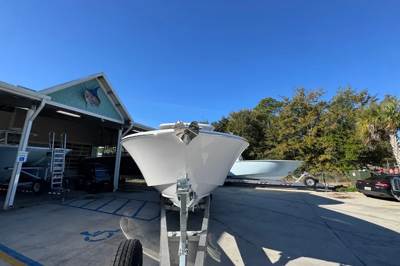 Slide: The Image of 2026 Bertram 34 CC boat on trailer outside a marina under clear blue sky. - 7