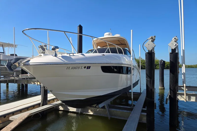 The Image of 2017 Sea Ray 310 Sundancer yacht docked on a lift under clear blue skies. - 0