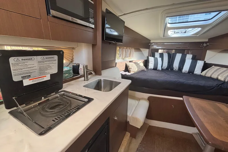 Slide: The Image of Interior of 2017 Sea Ray 310 Sundancer with kitchenette and cozy sleeping area. - 13