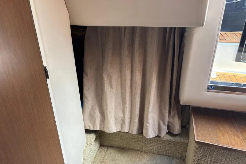 Slide: The Image of Interior cabin view of 2017 Sea Ray 310 Sundancer with curtain and wooden accents. - 17