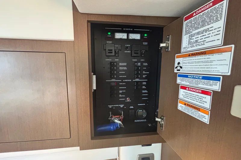 Slide: The Image of Electrical panel inside 2017 Sea Ray 310 Sundancer boat with safety warnings. - 18