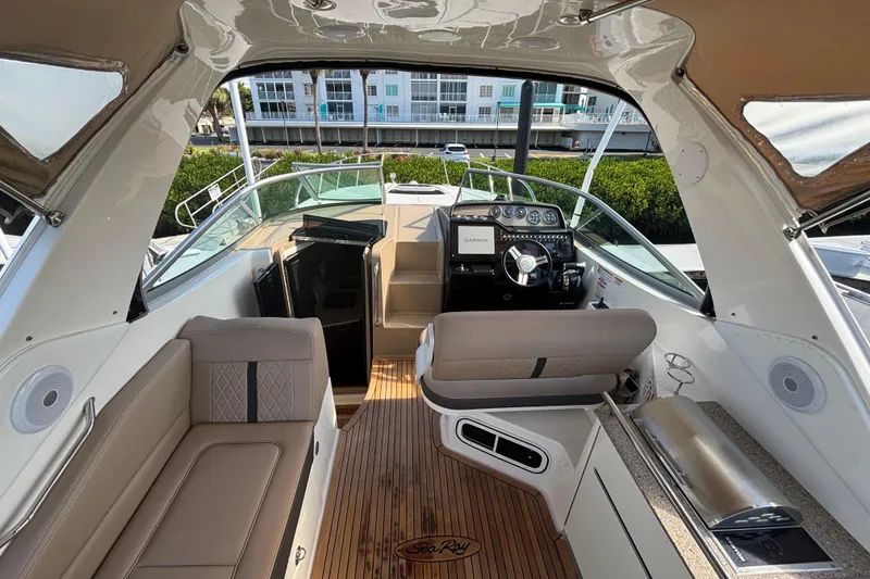 Slide: The Image of 2017 Sea Ray 310 Sundancer cockpit with modern helm, seating, and wood flooring. - 5